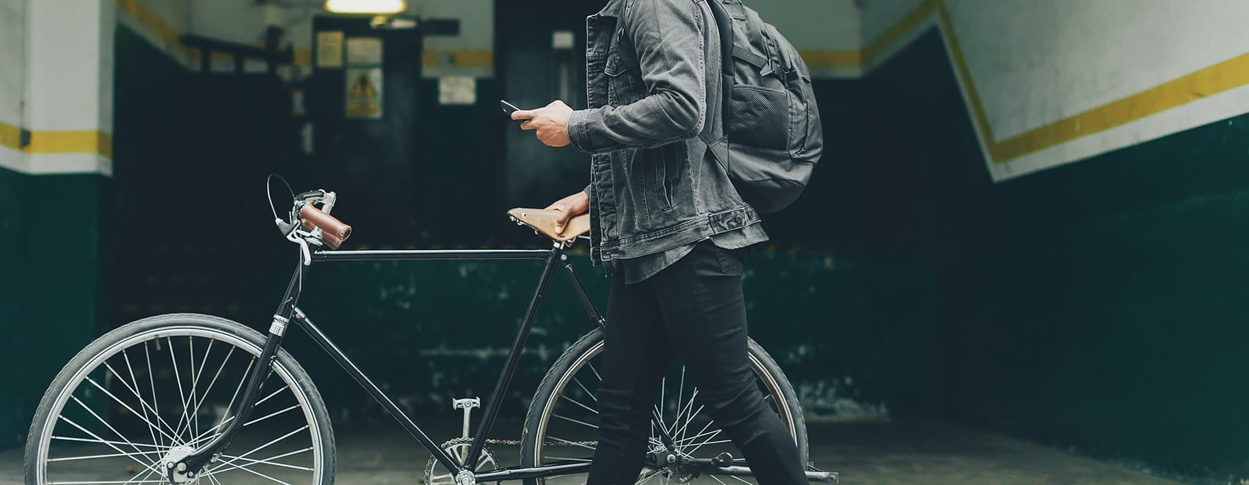 lifestyle image of a person walking with their bicycle