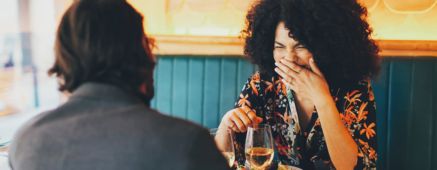 lifestyle image of a woman laughing in a restaraunt